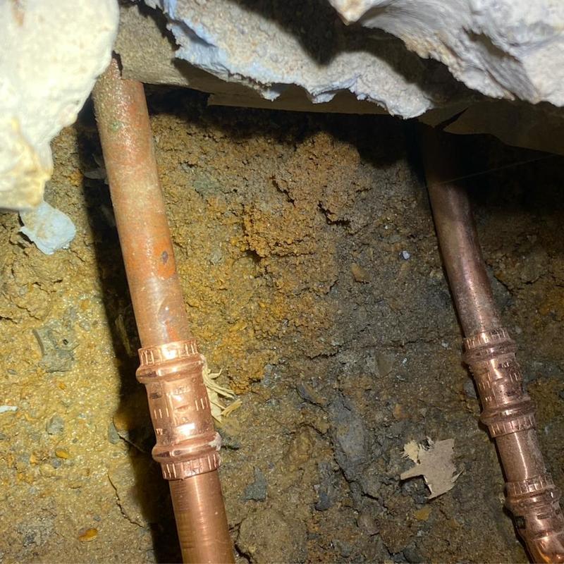 Copper water lines under concrete slab in kitchen cabinetry