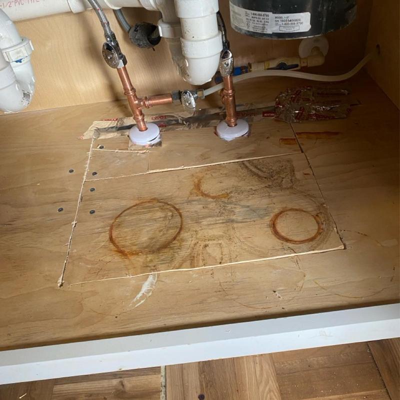 Copper water line beneath kitchen cabinet cutout