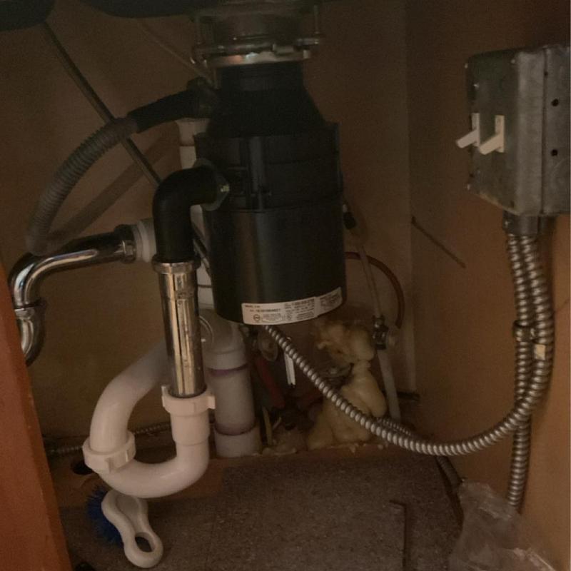 Garbage disposal installation with drain pipes under sink
