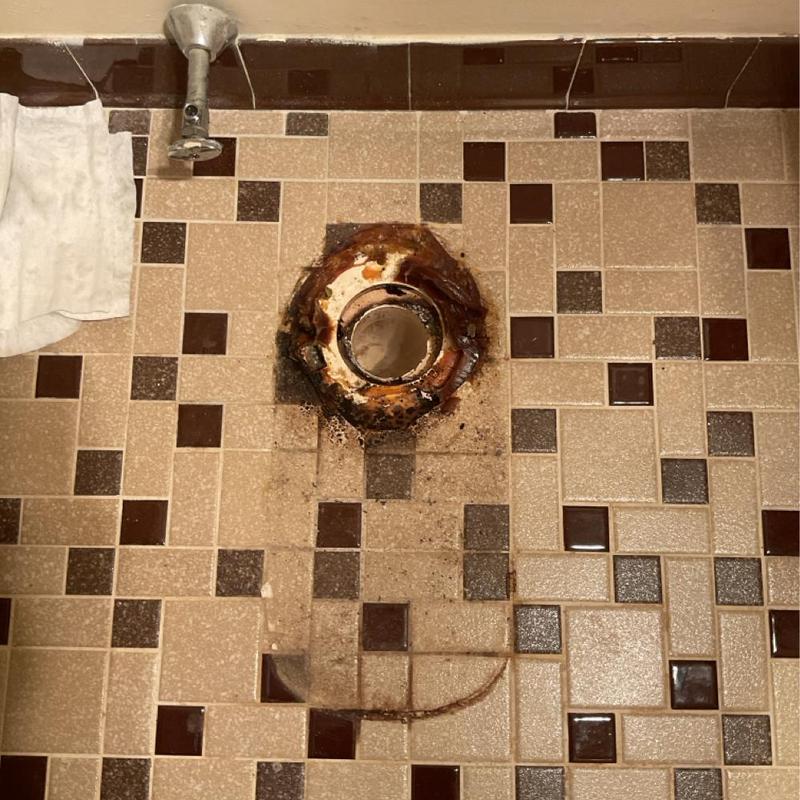 Toilet flange and drain on tiled floor removal site
