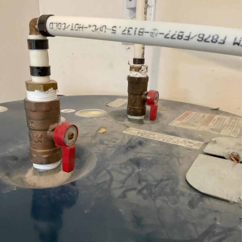 Water heater copper valves with white PVC piping