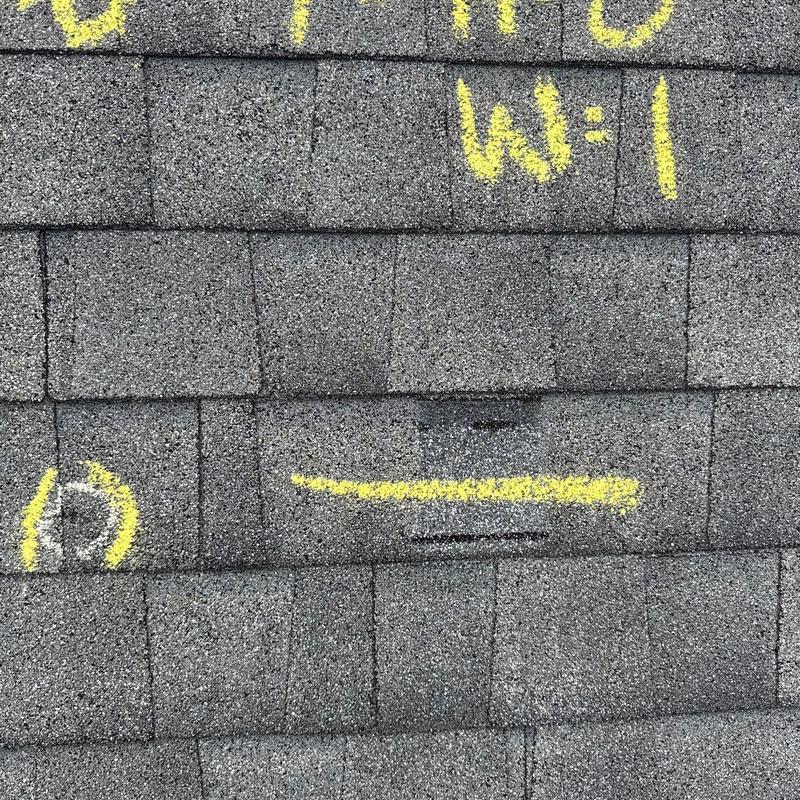 Roof shingles with hail damage markings and discoloration
