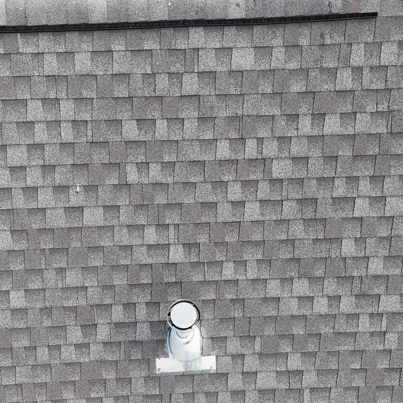 Shingles with metal vent pipe and flashing on roof