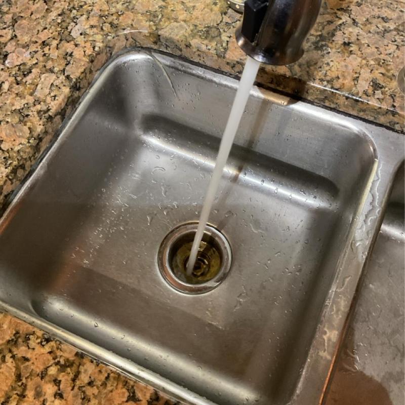 Kitchen sink drain cleaning with running water Kitchen sink drain cleaning with running water