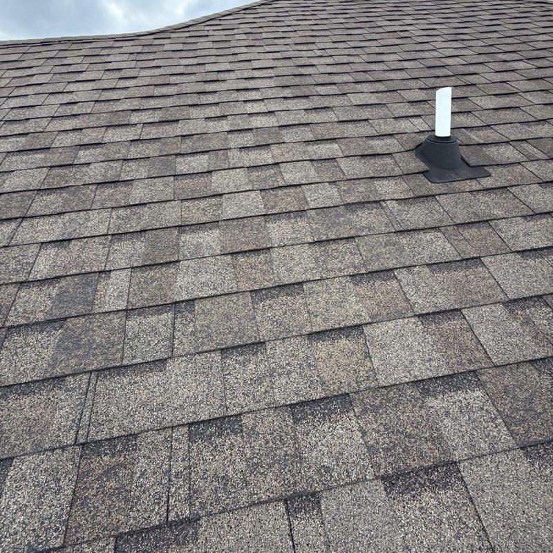 Asphalt shingles with hail damage near vent pipe