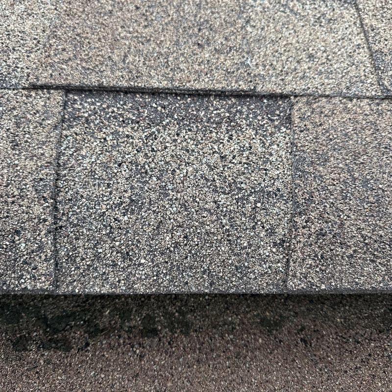 Asphalt shingle surface with visible hail impact damage