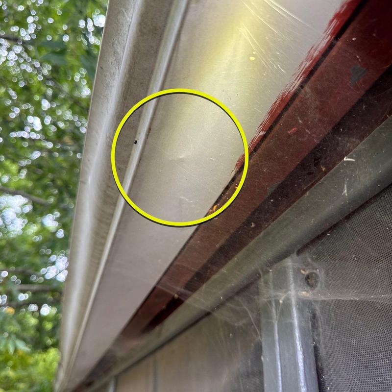 Metal roof flashing with minor hail damage highlighted