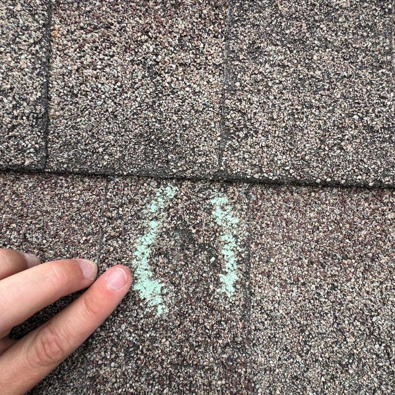 Asphalt shingle hail damage with marked wear detail