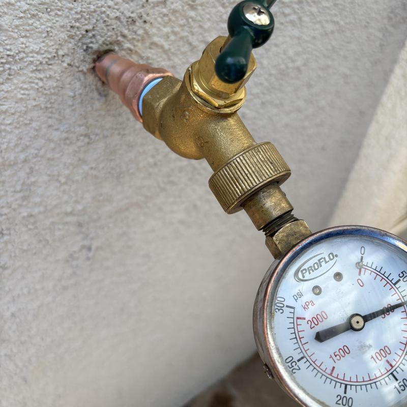 Hose bib with pressure gauge and adapter attached