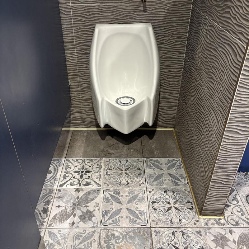 Waterless urinal with new cartridge in commercial restroom