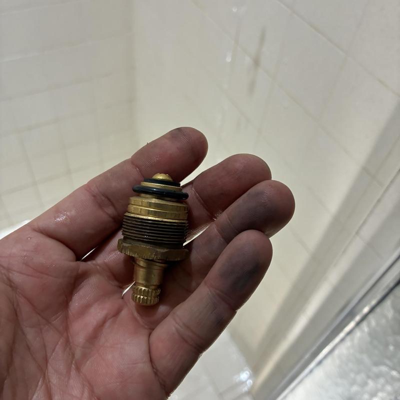 Two-handle shower faucet stem replacement part in hand