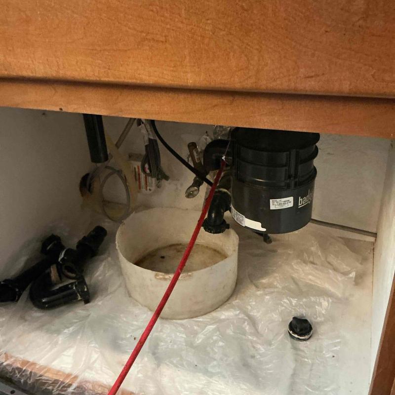 Kitchen drain line with rigid snake clearing blockage