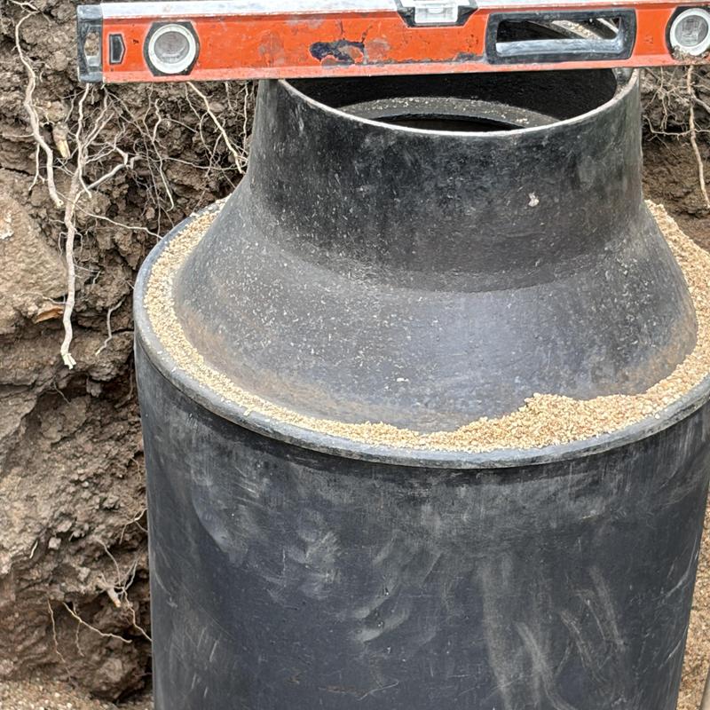 Meter pit installation with level tool on soil site