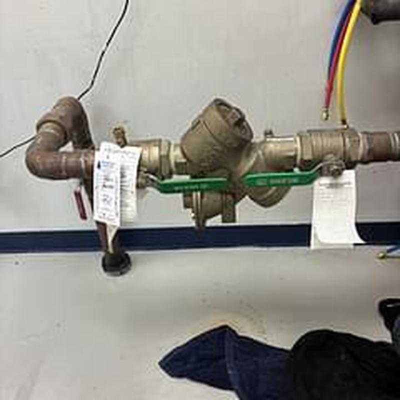 Backflow prevention device with test tags on pipes