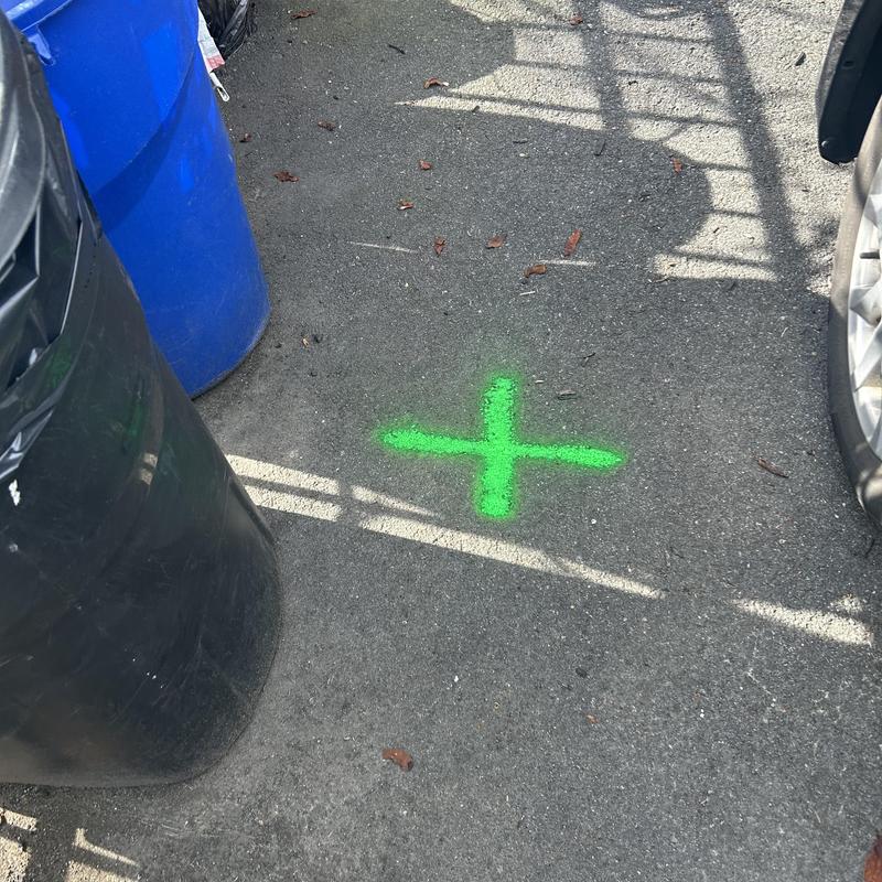 Sewer line location marked on asphalt for camera inspection