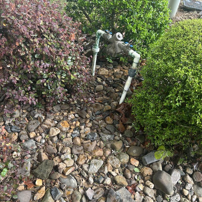 RPZ valve and lawn sprinkler system in rocky garden bed