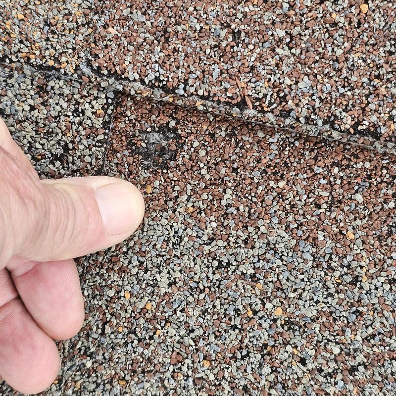 Asphalt roof shingle with hail damage close-up