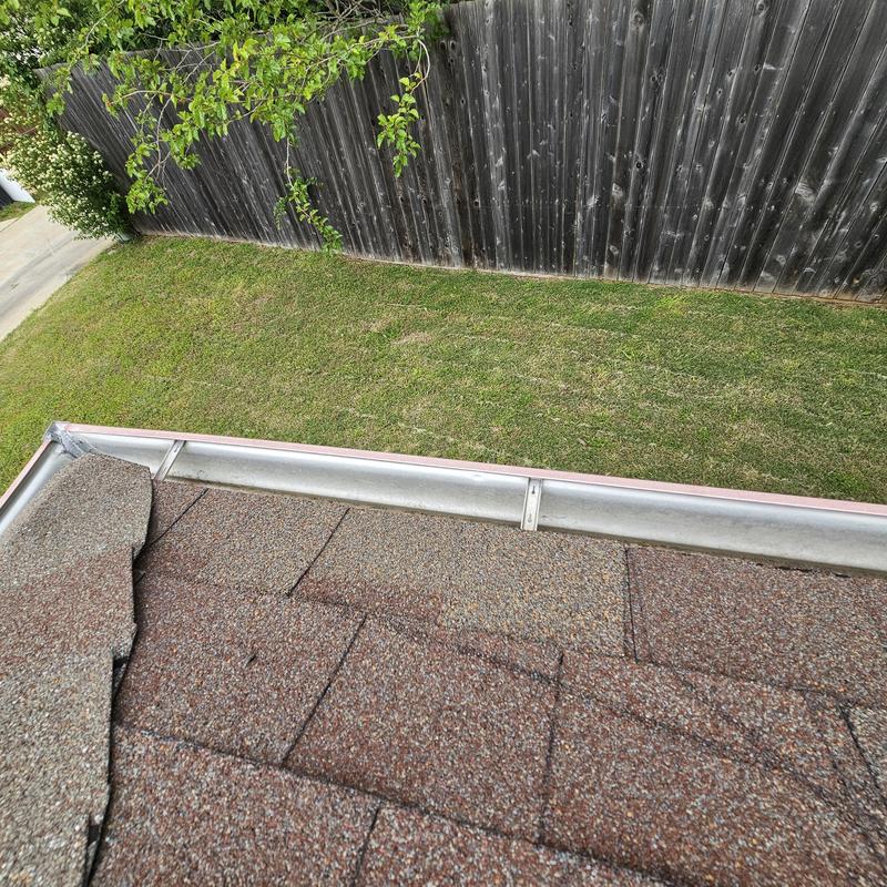Roof shingles with hail damage near gutter edge