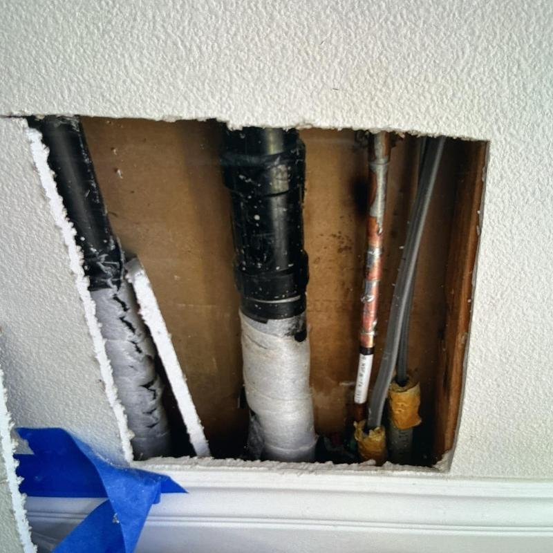 PEX tubing and copper manifold piping inside wall cavity