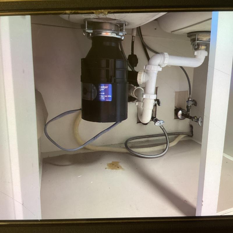 Garbage disposal with reinstalled waste outlet pipes under sink