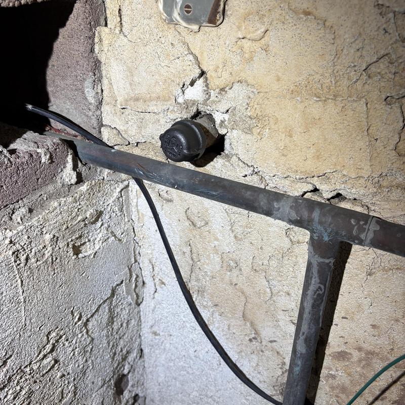 Gas line capped in backyard near garage wall