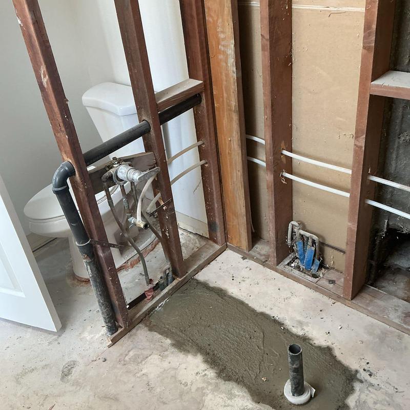 Bathroom drain pipe with fresh concrete patch