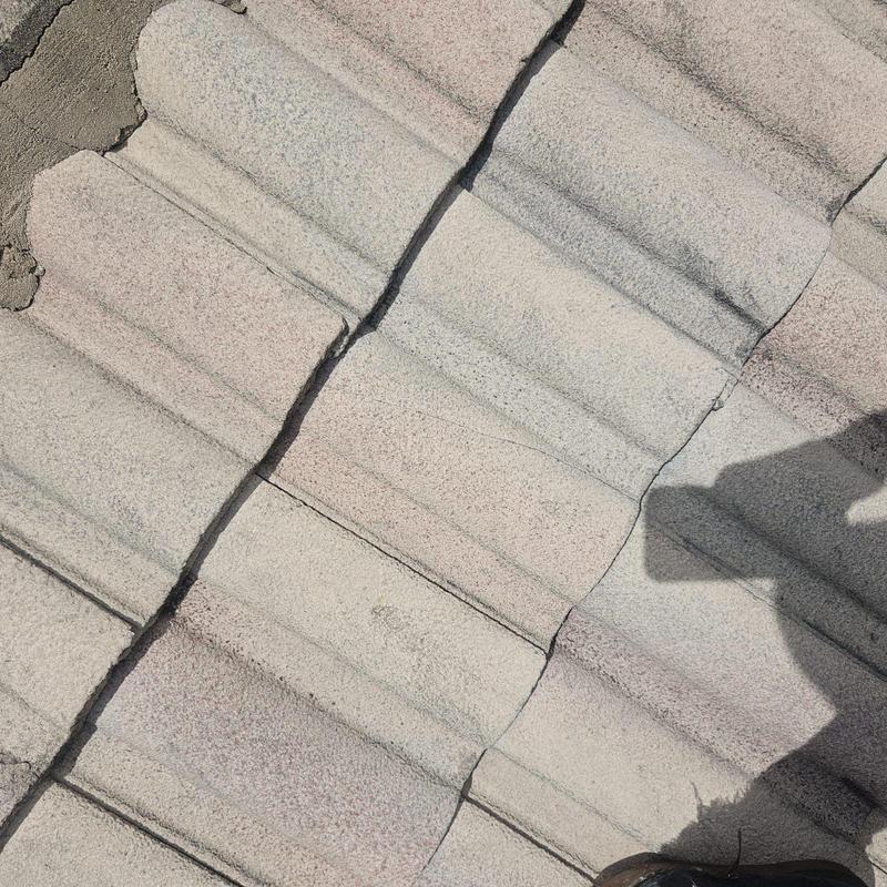 Concrete tile roof with broken tiles and cracked mortar