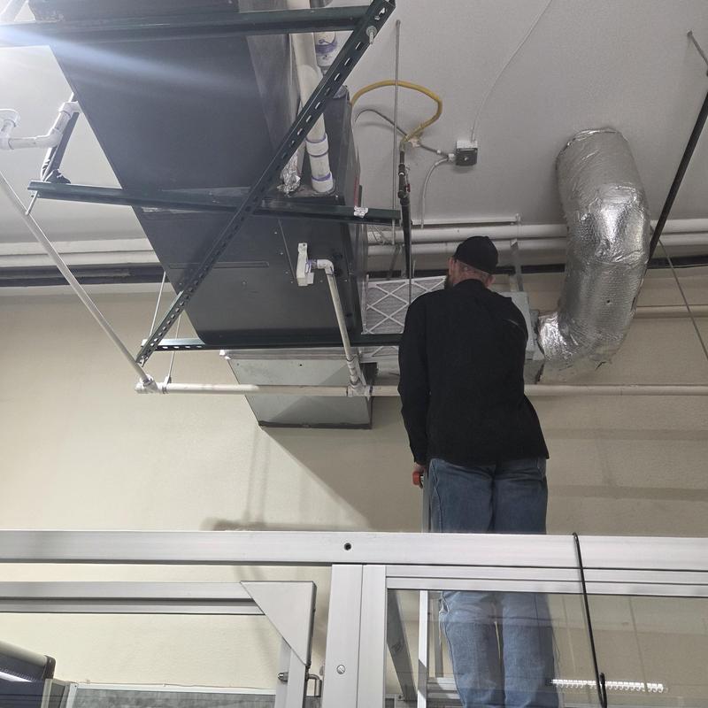 HVAC air duct system with technician inspecting filter