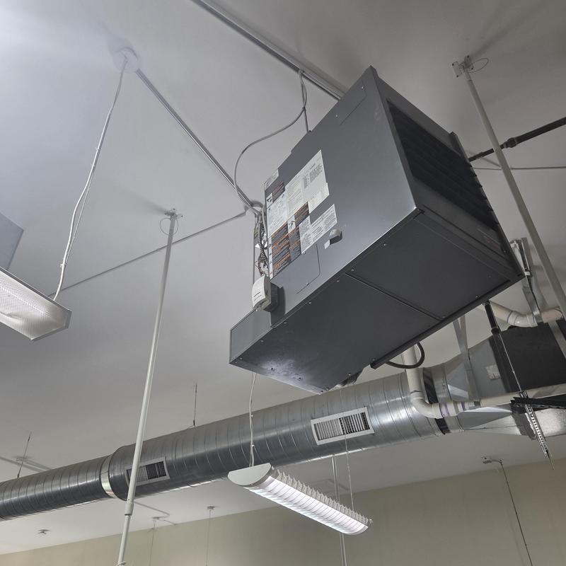 Ceiling-mounted HVAC air handler with ductwork in room