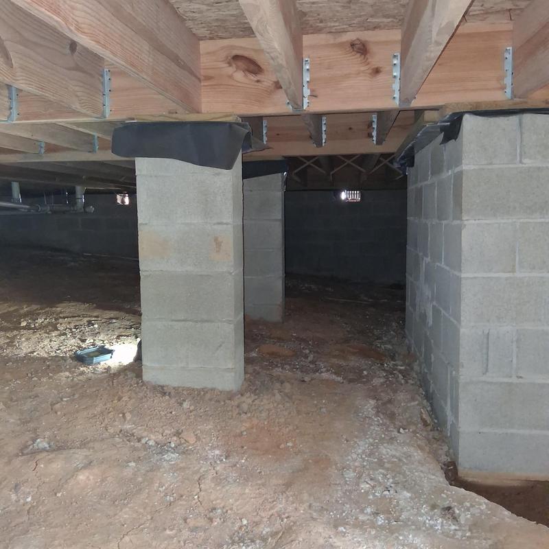 Moisture barrier installation under wooden subfloor joists