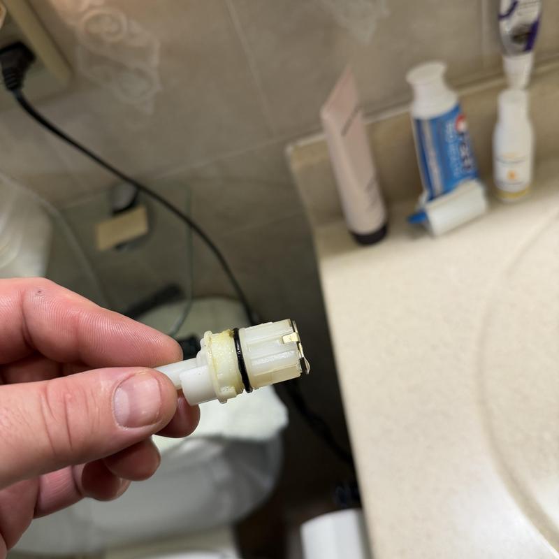 Faucet cartridge with O-ring held by hand in bathroom