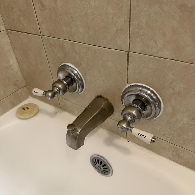 Bathtub faucet handles and spout with tile wall