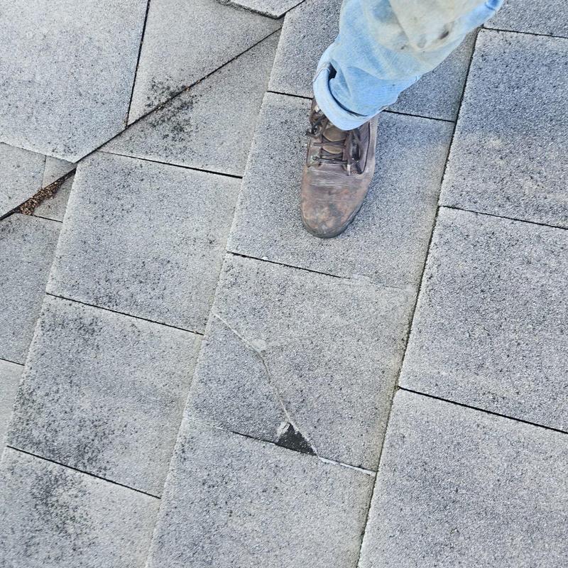 Concrete tile roof with cracked tiles and worn boot