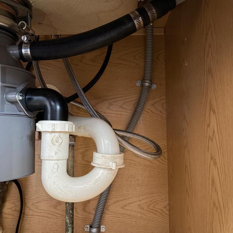 Dishwasher drain line and kitchen faucet plumbing under sink