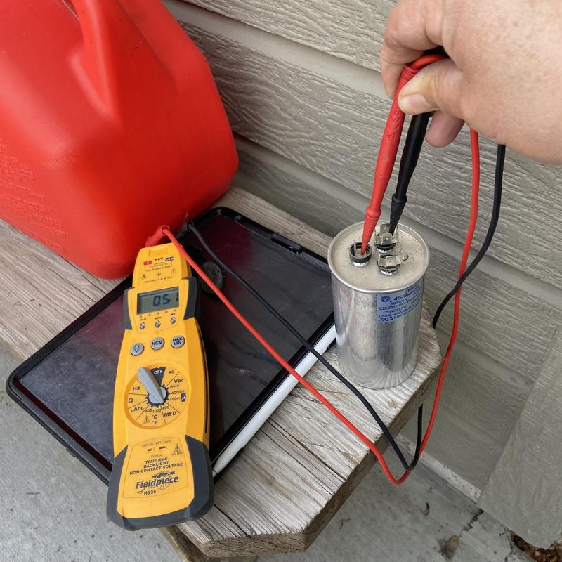 HVAC capacitor testing with multimeter on deck
