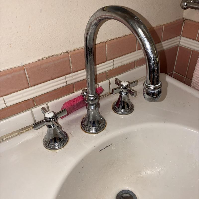 Widespread faucet with chrome handles in bathroom sink