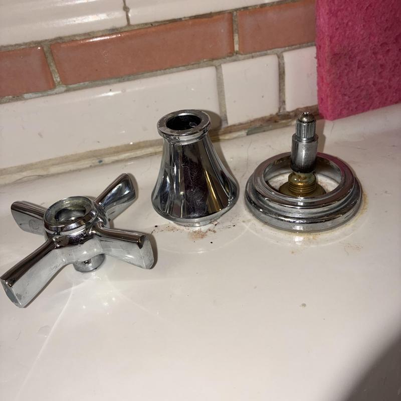 Faucet handle and trim pieces on sink countertop