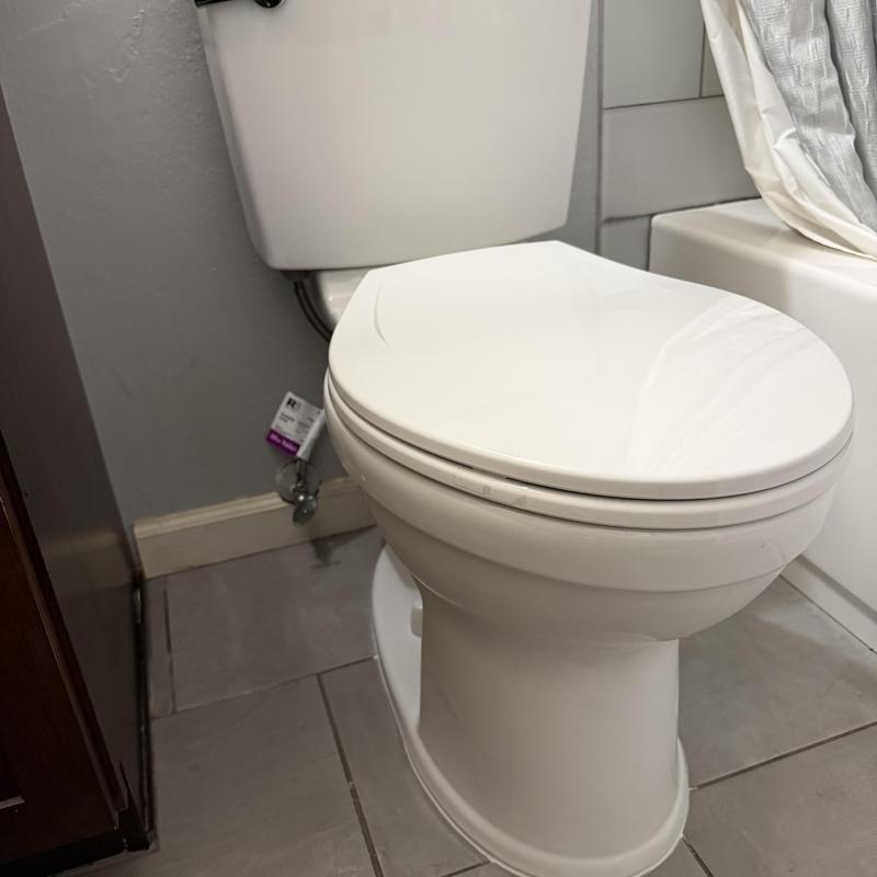 Toilet with closed lid in bathroom corner