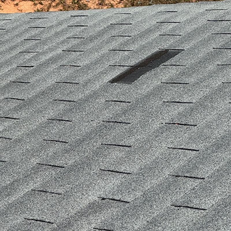 Asphalt shingle roof with damaged granule patch