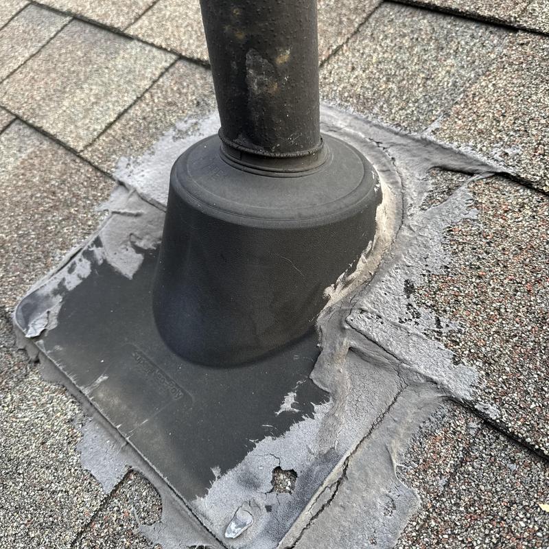 Roof pipe boot with deteriorated asphalt sealant on shingles