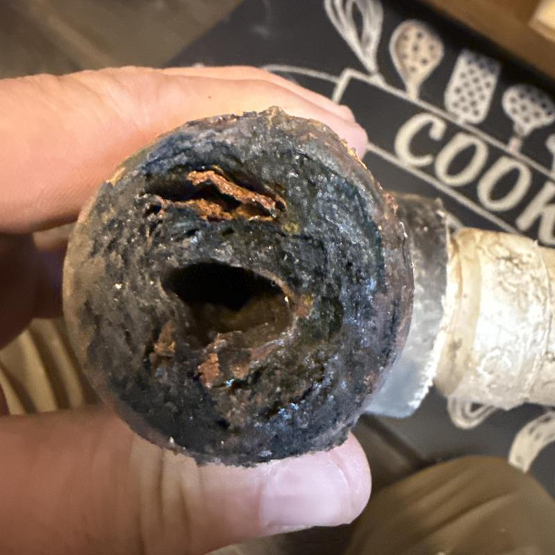 Clogged corroded drain pipe section close-up