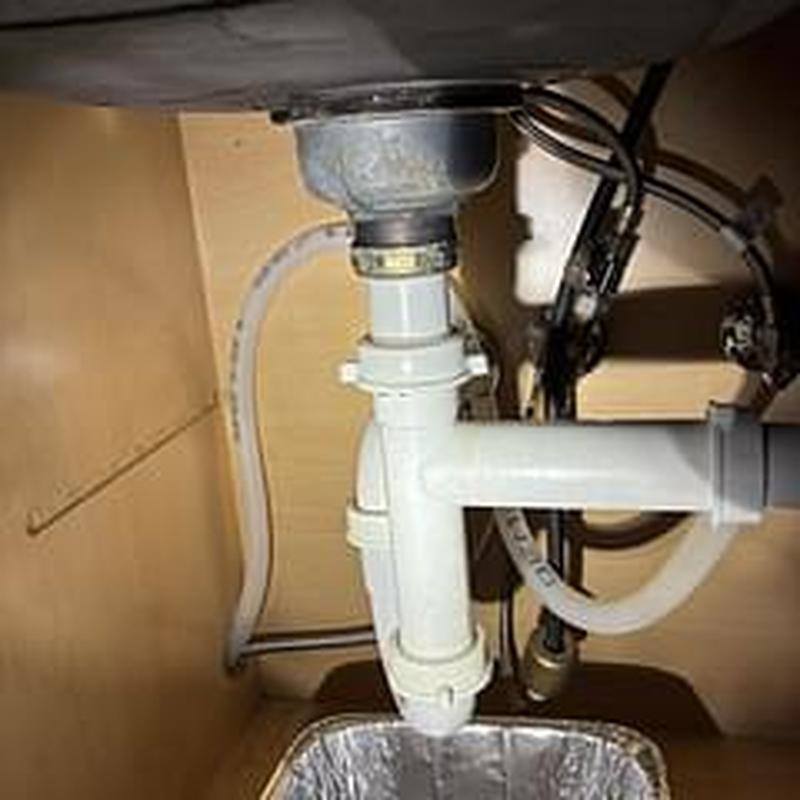 Basket strainer and drain pipes under kitchen sink