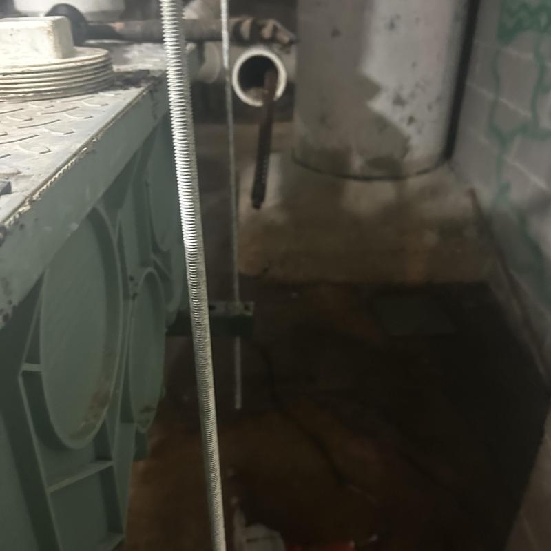 Sewer cleanout pipe with plumbing jet hose in basement