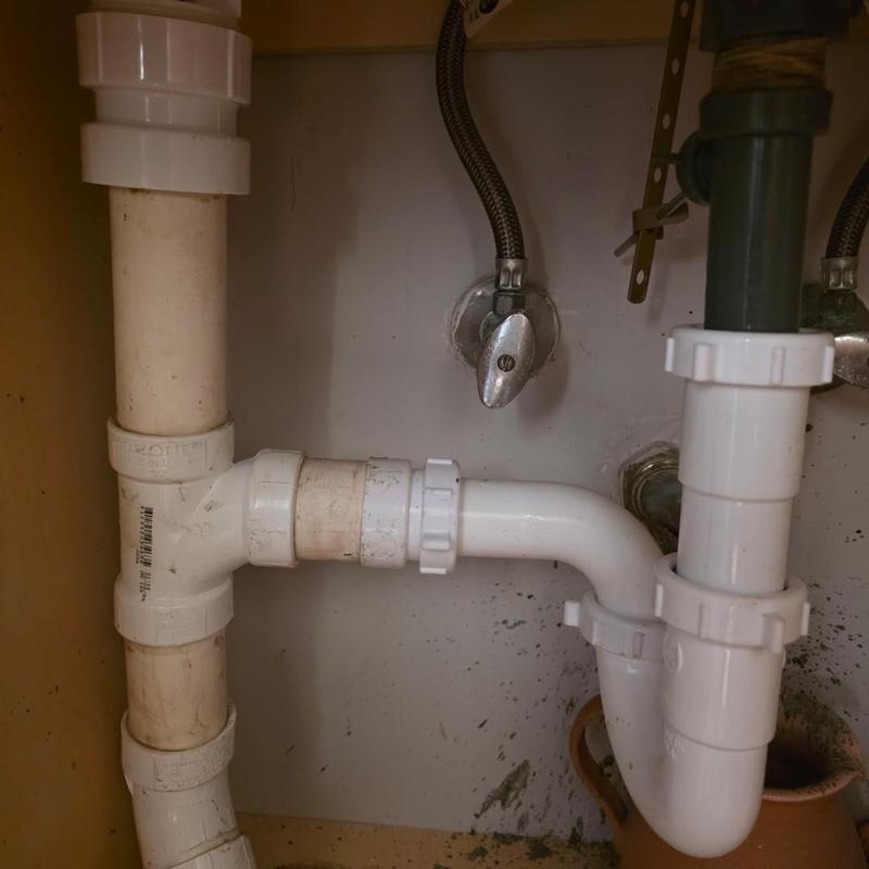PVC drain pipes under sink with valve connections