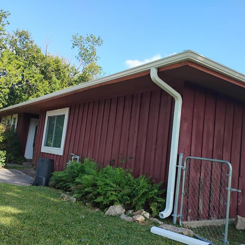 Aluminum seamless gutter with downspout on red house Aluminum seamless gutter with downspout on red house