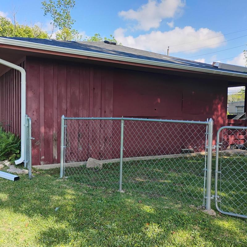 Aluminum seamless gutter with downspout on red building Aluminum seamless gutter with downspout on red building