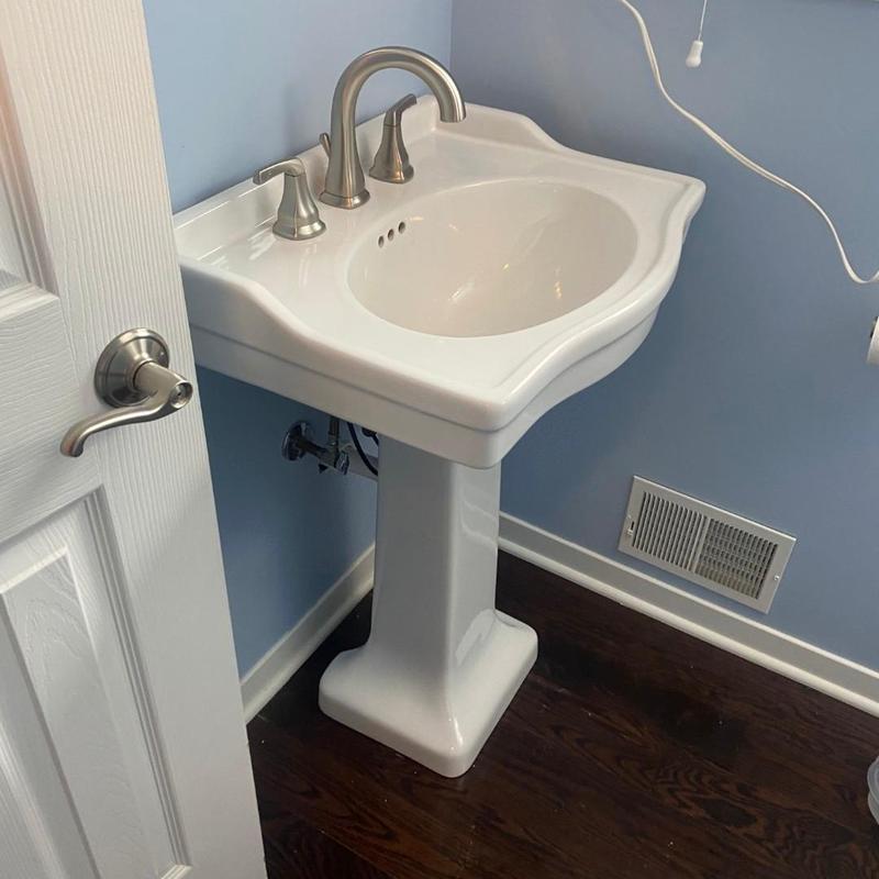 Pedestal sink with faucet and drain piping installed