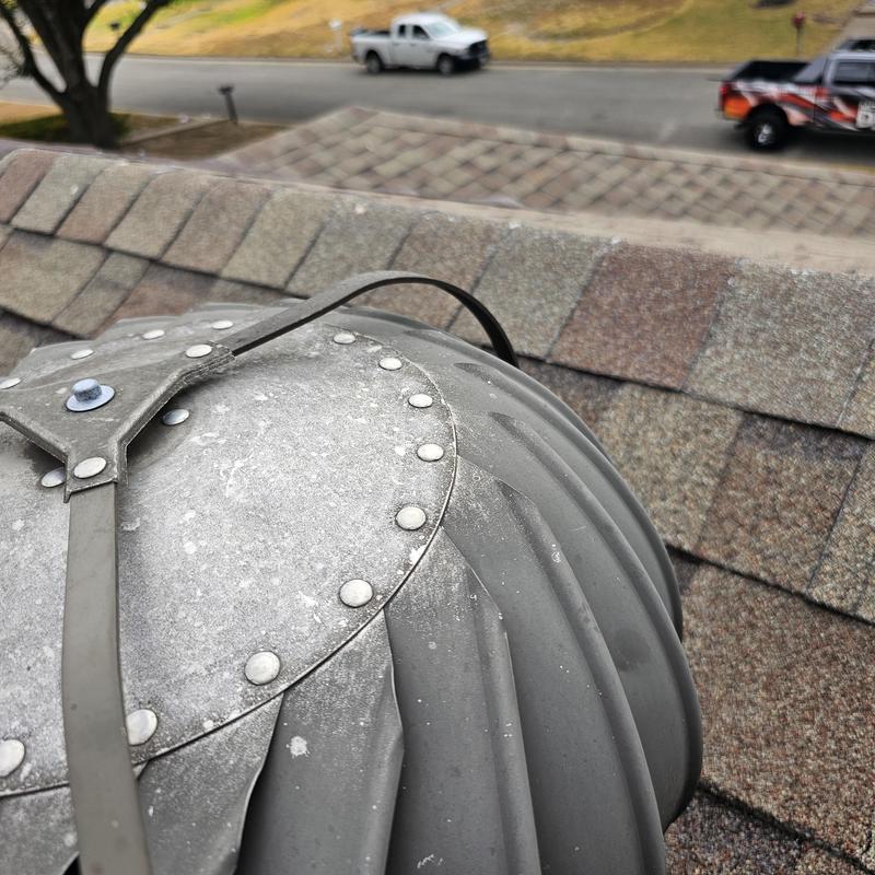 Roof turbine vent on shingle roof with hail damage