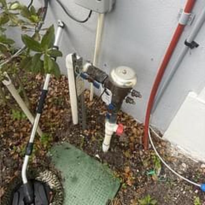 Backflow prevention device installed near wall outdoors