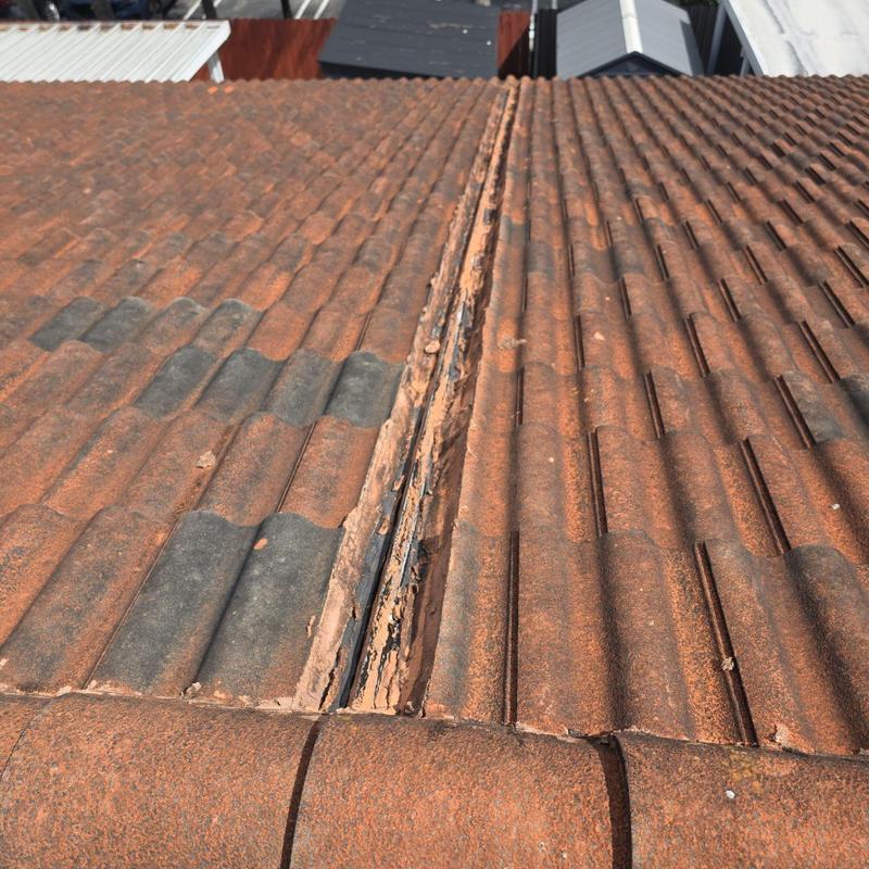 Tile roof with damaged ridge and missing tiles Tile roof with damaged ridge and missing tiles